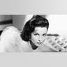 Yvonne Furneaux laying on a bed in a glamorous pose