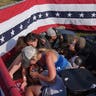 People huddle after Trump rally shooting