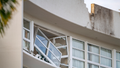 A broken window hands precariously at the Double Tree by Hilton Hotel in Cairns, Australia, after a helicopter crashed into its roof early Monday, Aug. 12, 2024. - Fox News