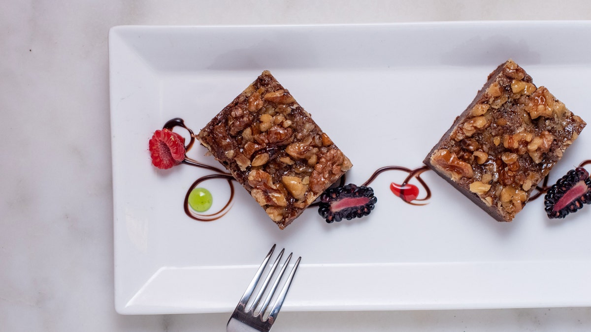 Un par de brownies de Palmer House se exhiben ornamentalmente en un plato blanco.