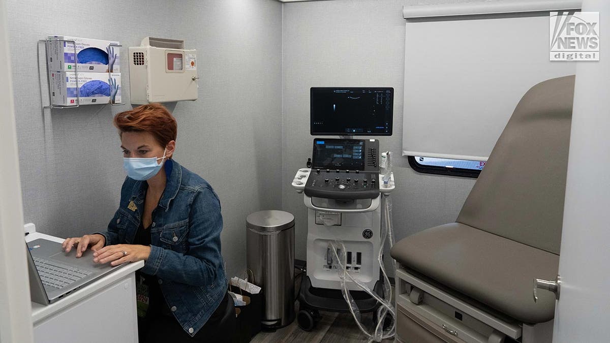 A doctor at a laptop in a mobile abortion clinic