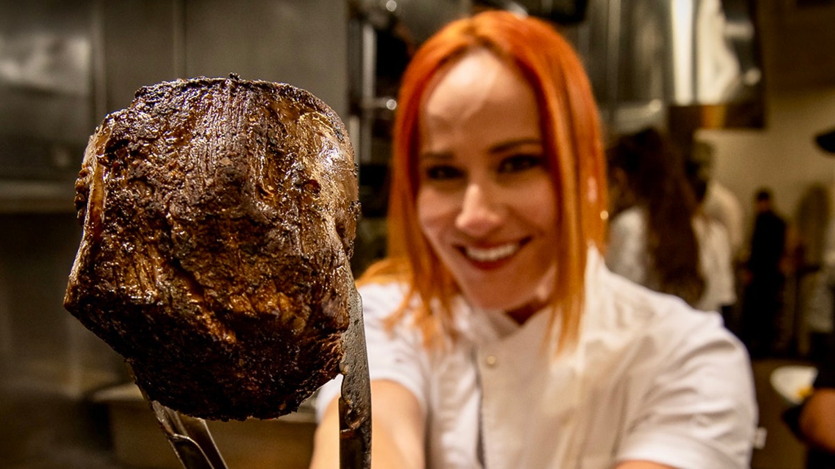 Adrianne Calvo holding a steak.