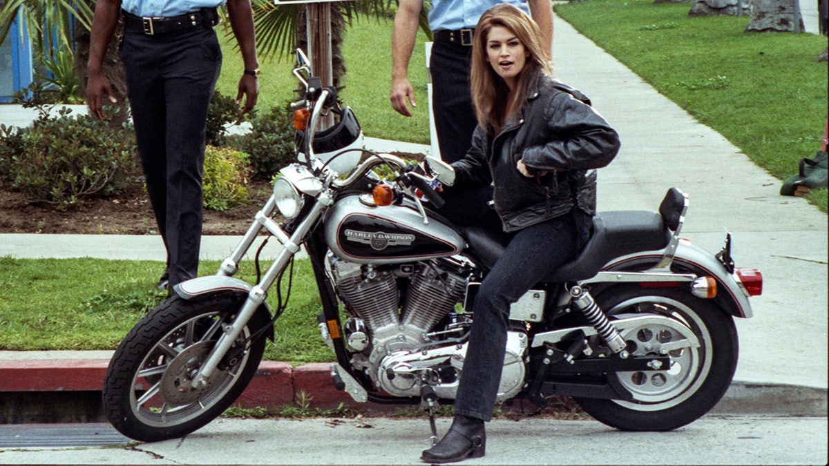 La actriz y modelo Cindy Crawford se sienta en una motocicleta Harley-Davidson en el plató de un anuncio de Pepsi en 1992 en Los Ángeles, California. Antiguos motoristas que defendieron la marca cuando era impopular en los años 70 dicen que su imagen empezó a cambiar en los 90.