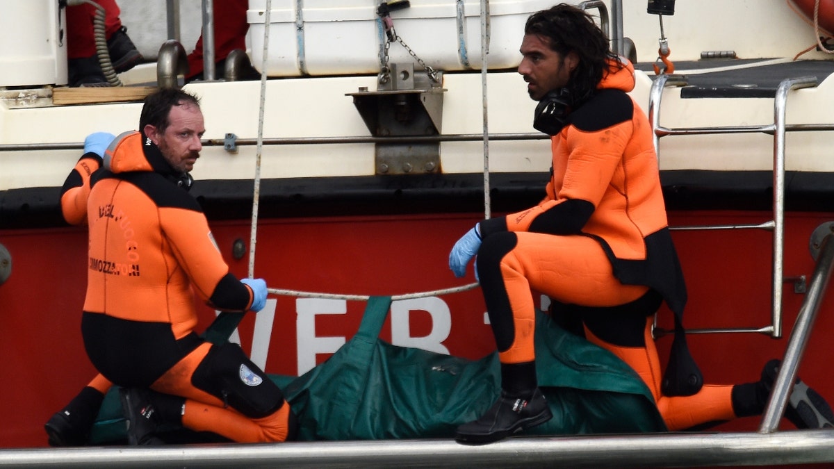 Italian firefighter divers bring ashore in the green bag the body of one of the victims of the British-flagged vessel Bayesian, Wednesday, August 21, 2024. The yacht was hit by a sudden violent storm and sank early Monday while at anchor off the Sicilian village of Porticello, near Palermo, in southern Italy.