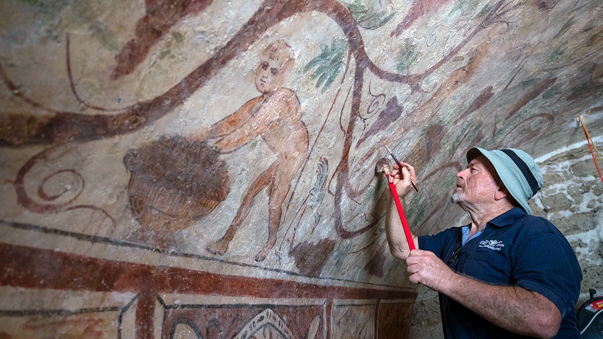 Un restaurador trabaja en la restauración del mural de la tumba de Ashkelon