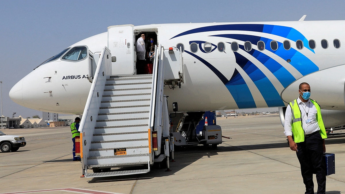 Employee of Luxors International Airport walks next to an EgyptAir plane, in Luxor