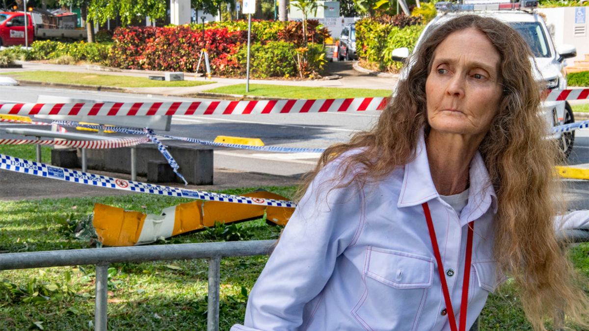 Woman looks at hotel wreckage after helicopter crash