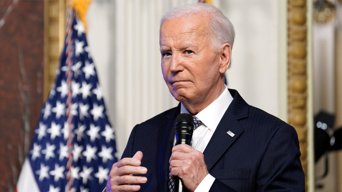 President Biden holding mic closeup photo