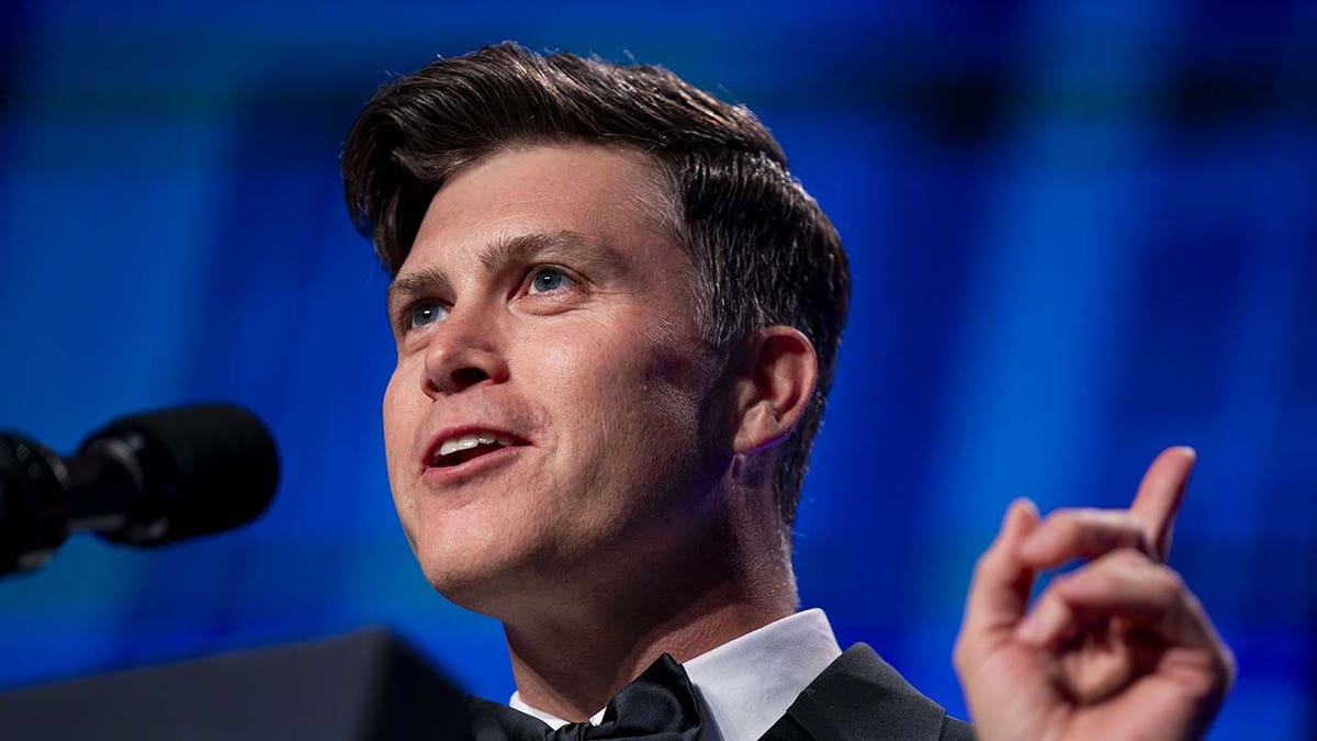 Colin Jost on stage during an event