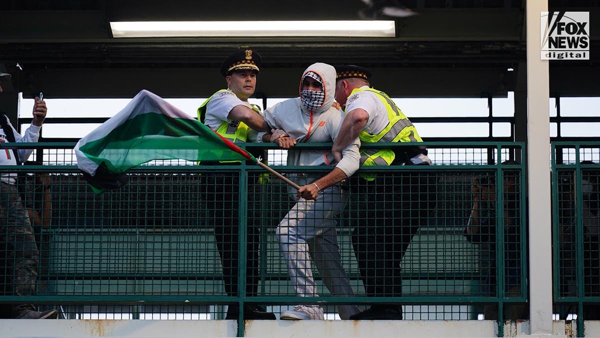 Police detain a man outside of a train at a station