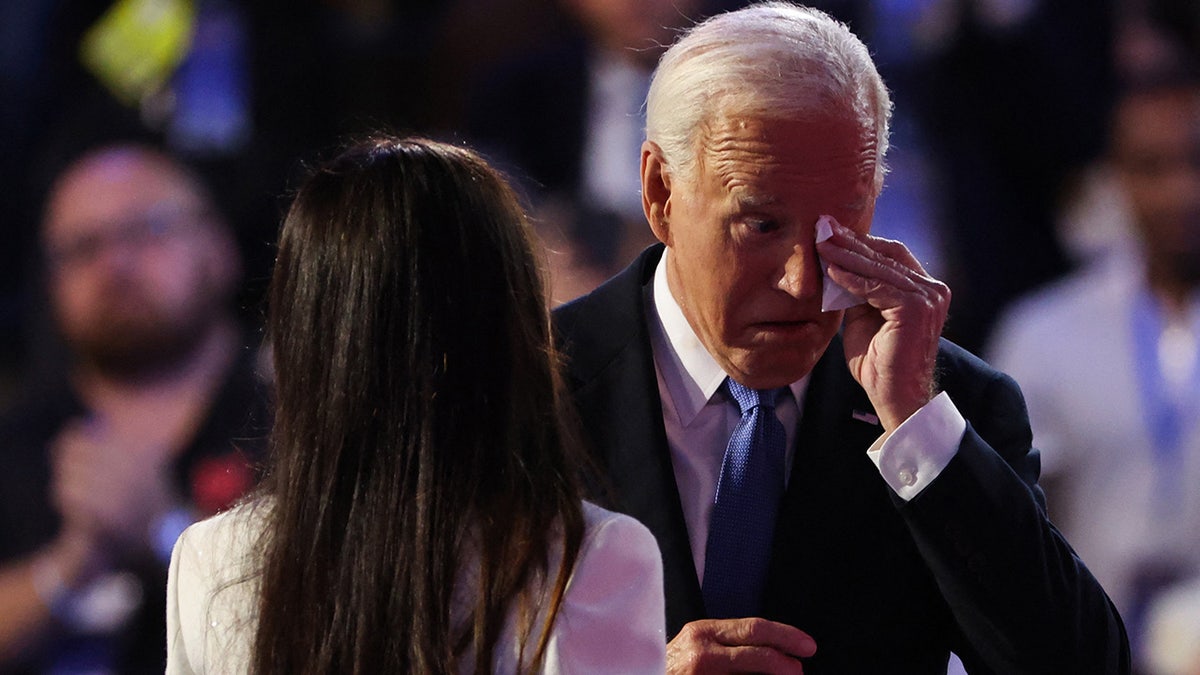 Joe Biden wipes his eyes next to daughter Ashley onstage during Day one of the Democratic National Convention