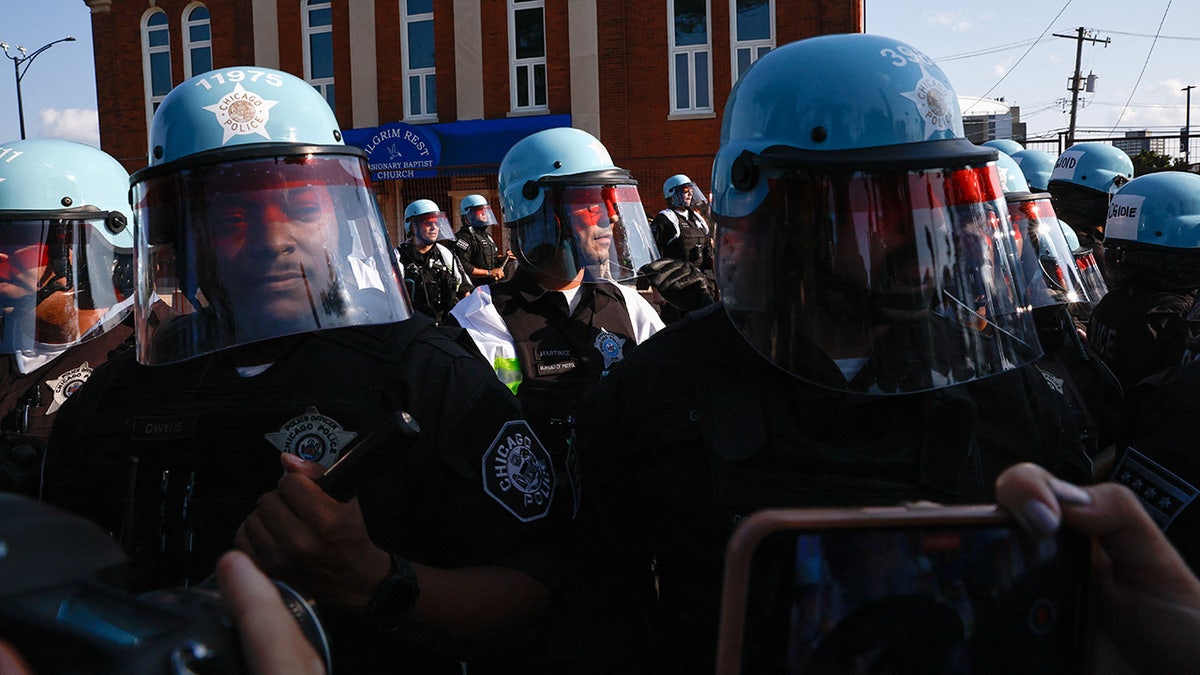 Agentes de la policía antidisturbios montan guardia frente a los manifestantes durante la concentración "March on the DNC" al margen de la Convención Nacional Demócrata.