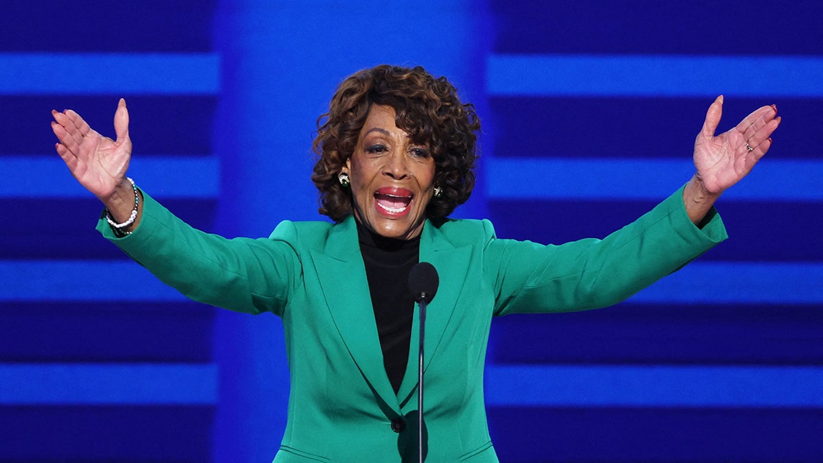 Maxine Water, D-Calif, in green suit with arms extended