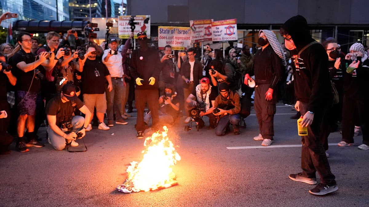 Protesters burn a flag near the Israeli Consulate during the Democratic National Convention