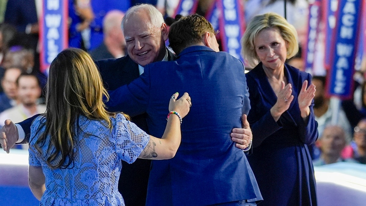 Tim Walz abraça seu filho Gus no palco do DNC