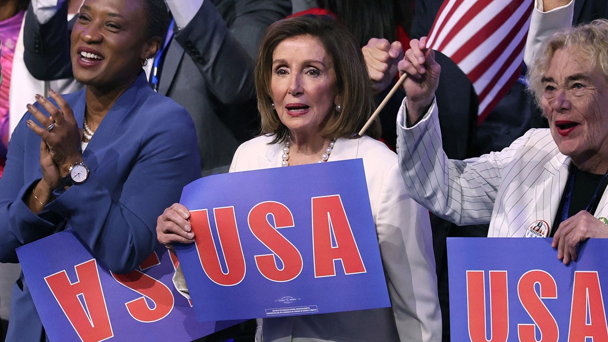 La diputada Nancy Pelosi (D-CA) sostiene un cartel de EE.UU. durante el cuarto día de la Convención Nacional Demócrata.