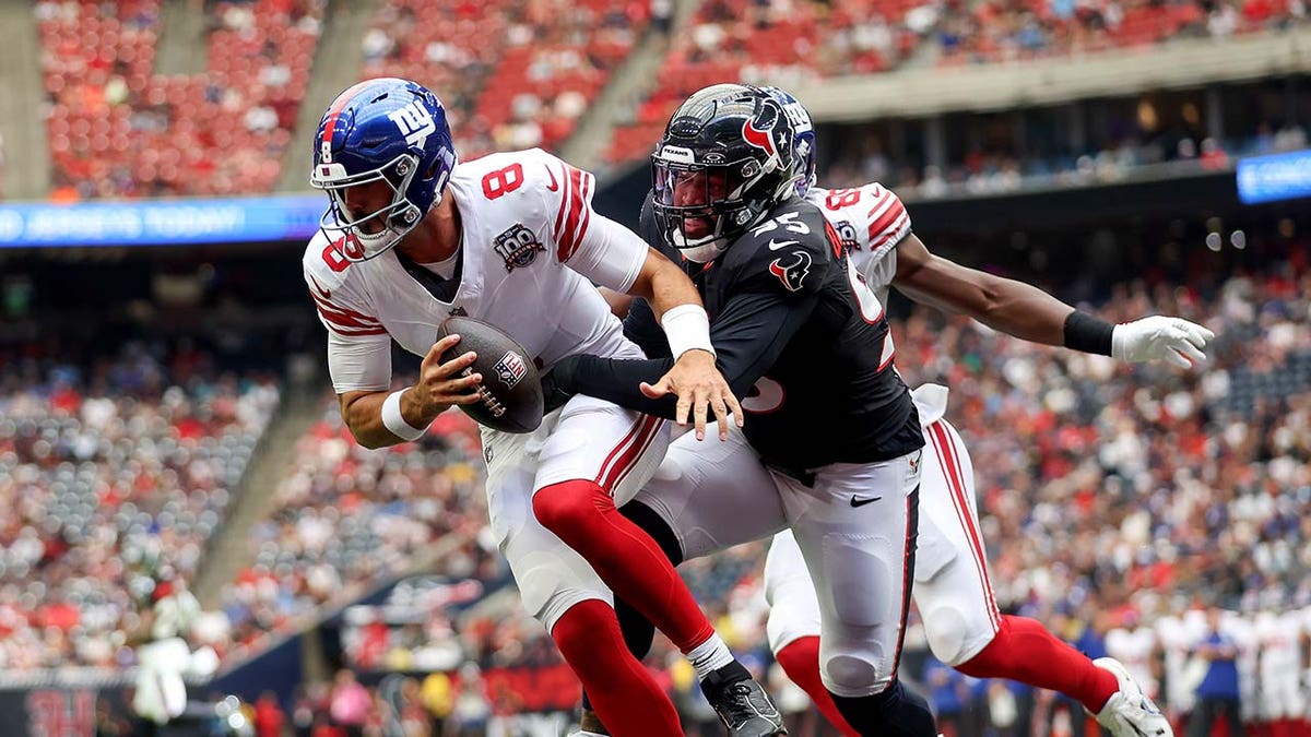 Daniel Jones attempts to throw during an NFL game