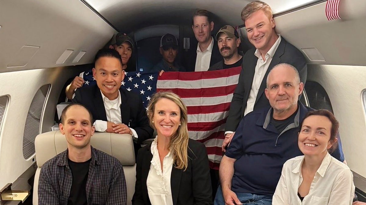 This image released by the White House shows Evan Gershkovich, left, Alsu Kurmasheva, right, and Paul Whelan, second from right, and others aboard a plane.