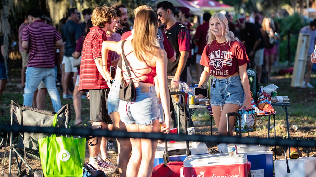 A Florida State Seminoles fan arrives at a tailgate carrying a six-pack of Angry Orchid cider Saturday, Sept. 24, 2022, in Tallahassee, Fla.