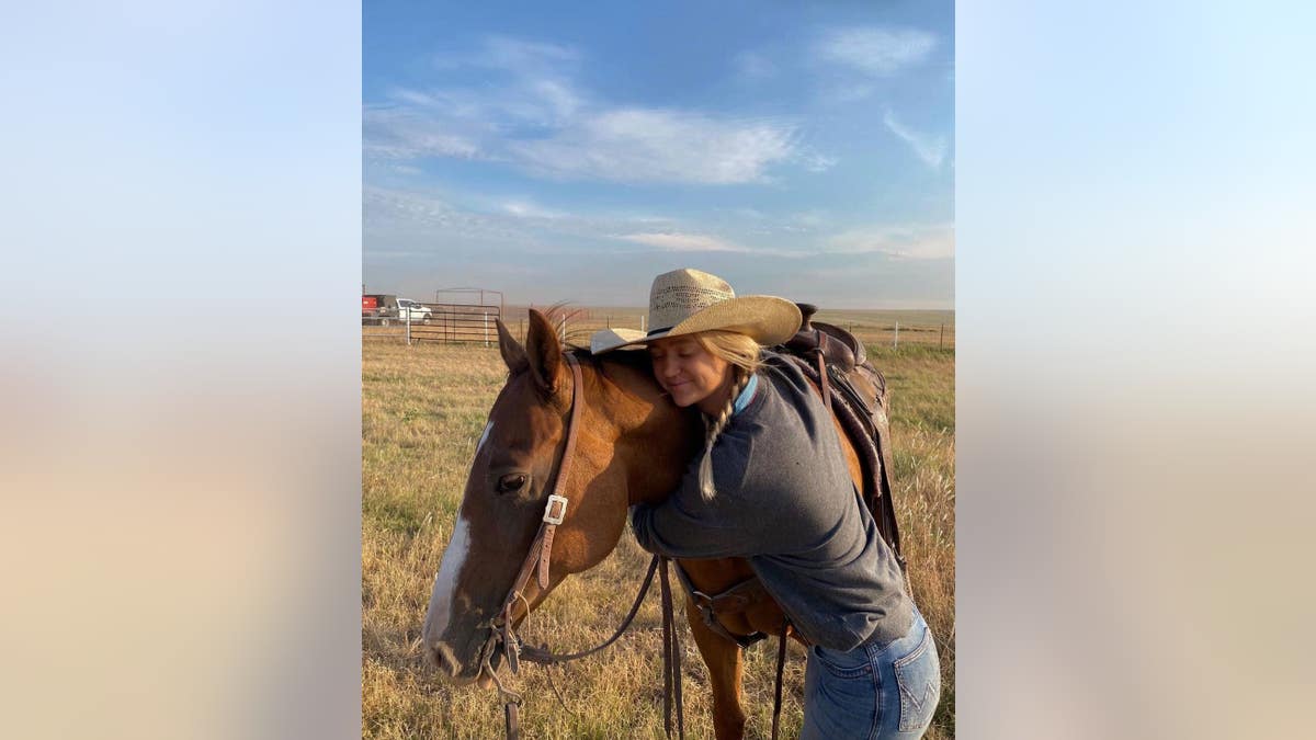 Paige Drummond hugs her horse 