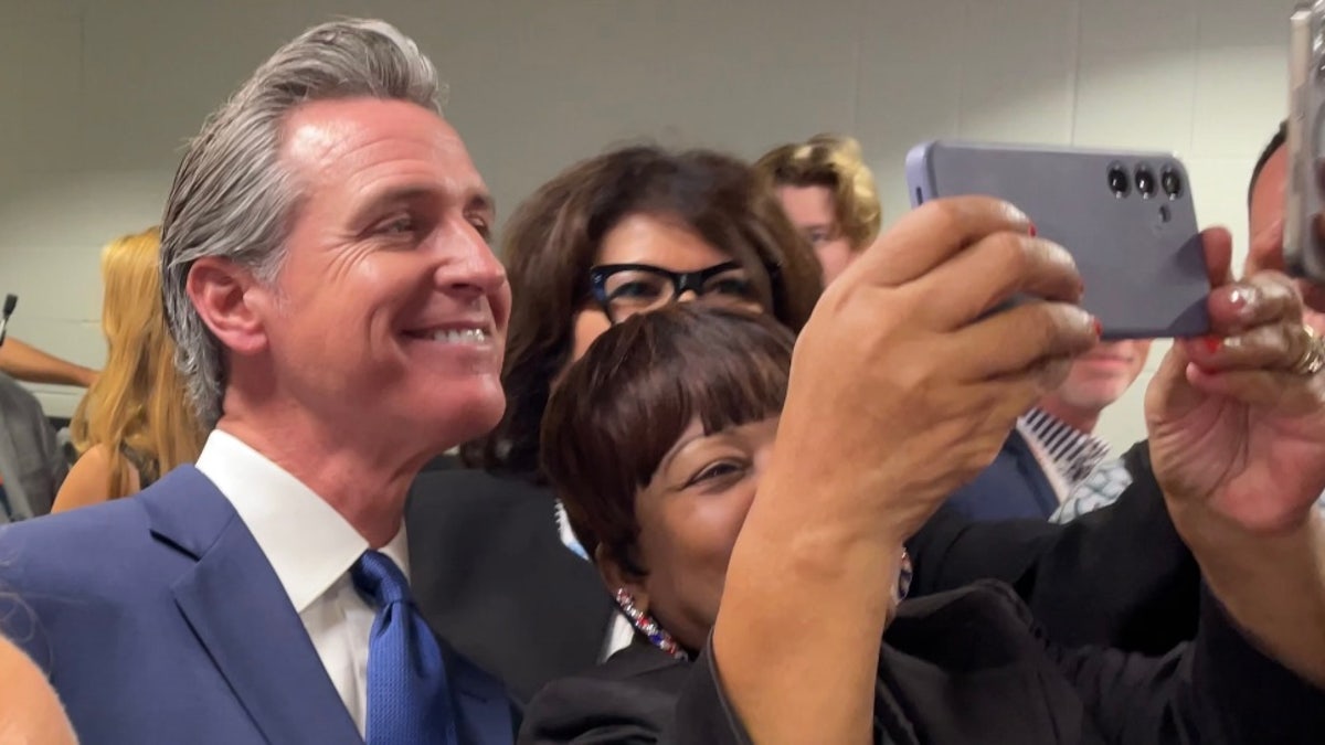 Gov. Gavin Newsom poses for a selfie photo with supporters at the Democratic National Convention in Chicago on Aug. 19, 2024.