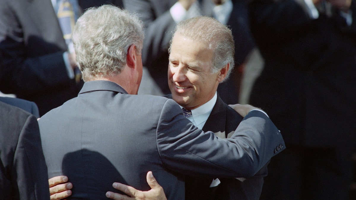 Bill Cinton and Joe Biden hug in 1994