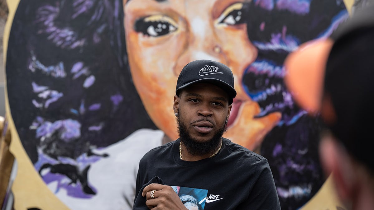 Walker in front of Breonna Taylor's mural