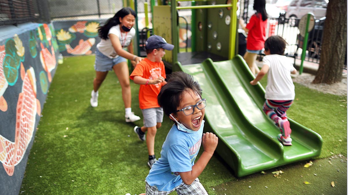 Children and teacher assistants at The Kwong Kow Chinese summer school play at a local park on July 21, 2022, in Boston. (John Tlumacki/The Boston Globe via Getty Images)