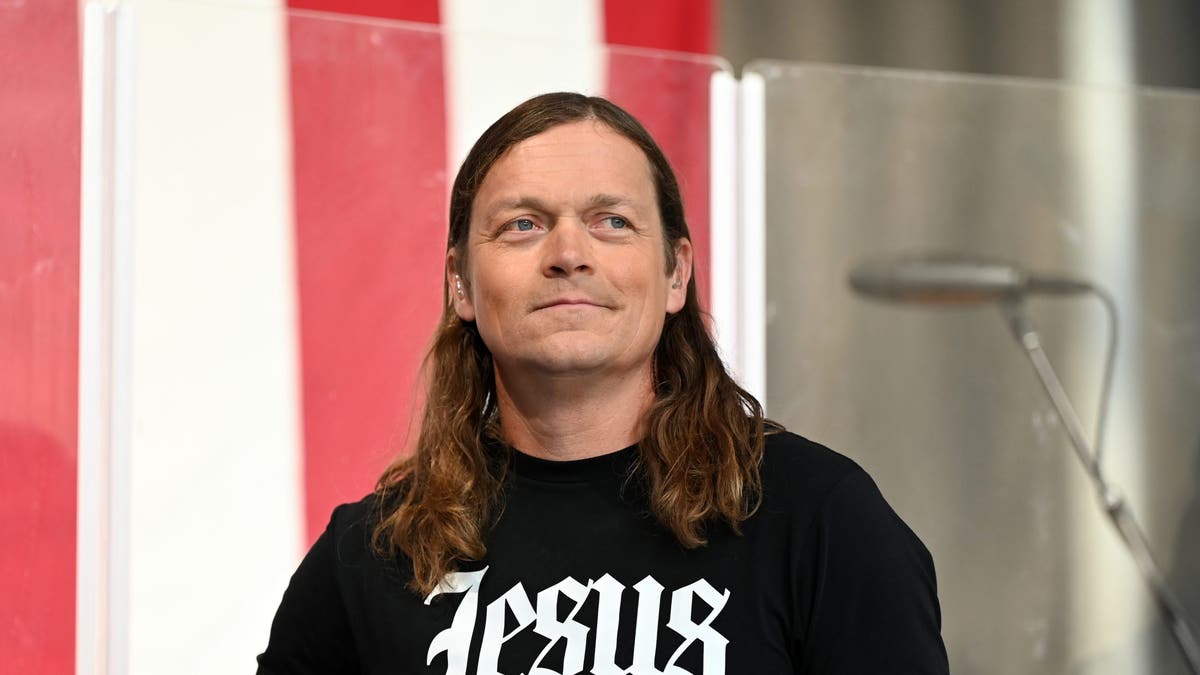 Brad Arnold of the band Three Doors Down smiles with Jesus shirt