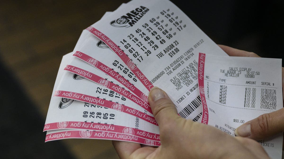 Uma pessoa segura seus bilhetes de loteria Mega Millions na cidade de Nova York em 08 de agosto de 2023. Se ganho, seria o maior prêmio concedido na história da loteria, de 1,58 bilhão de dólares, com uma opção em dinheiro de 757,2 milhões de dólares. (Foto de ANGELA WEISS/AFP via Getty Images)