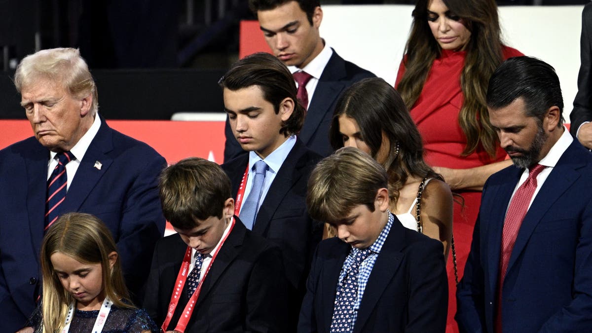 El ex presidente estadounidense y candidato presidencial republicano para 2024, Donald Trump, se inclina en oración junto a sus nietos durante el tercer día de la Convención Nacional Republicana de 2024 en el Fiserv Forum de Milwaukee, Wisconsin, el 17 de julio de 2024. Días después de sobrevivir a un intento de asesinato, Donald Trump ganó la nominación formal como candidato presidencial republicano y eligió al senador estadounidense de Ohio J.D. Vance como compañero de fórmula. (Foto de Brendan SMIALOWSKI / AFP) (Foto de BRENDAN SMIALOWSKI/AFP vía Getty Images)