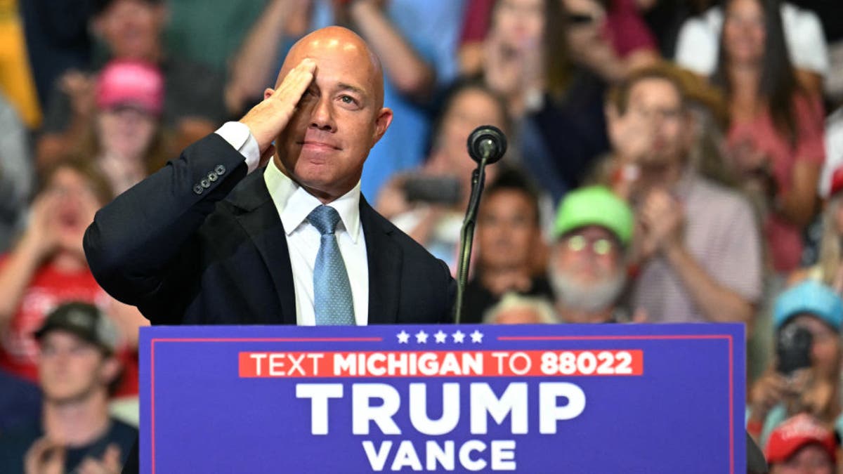 Brian Mast en el mitin de Trump saludando detrás del atril