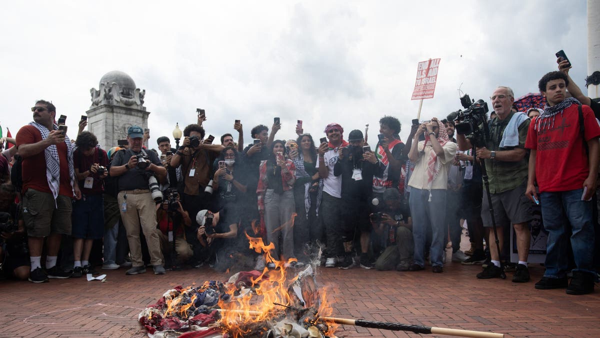 Anti-Israel protesters burn a US flag in Washington DC