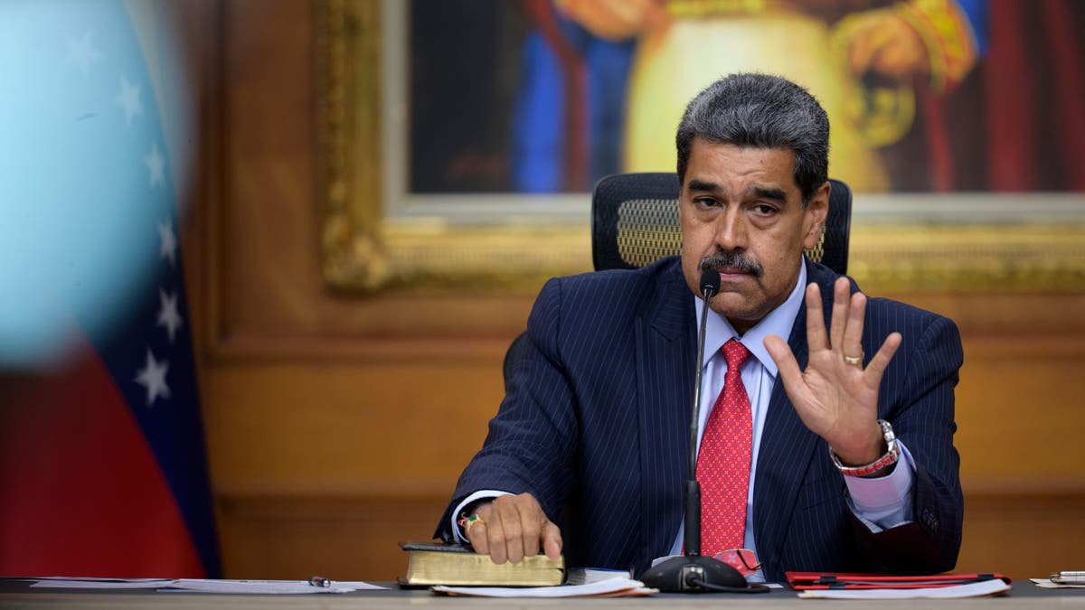 Nicolas Maduro holding up his hand