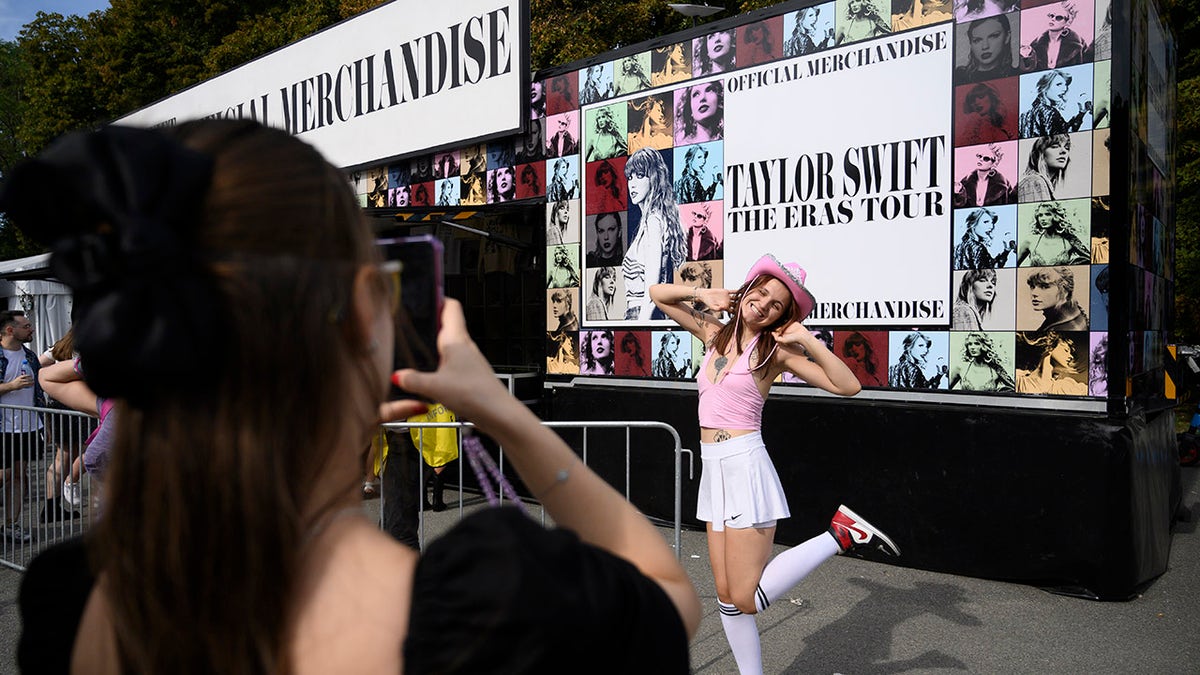 Una chica posa delante del cartel de un concierto de Taylor Swift en Varsovia