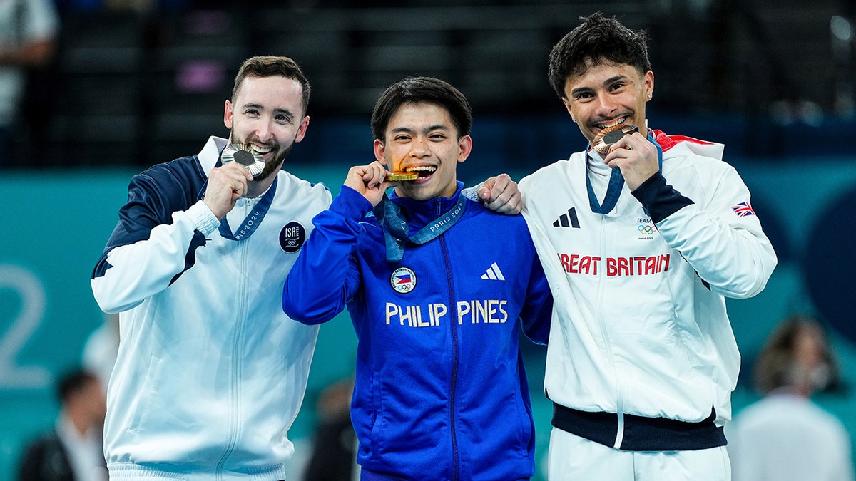 Silver medalist Artem Dolgopyat of Israel, Gold medalist Carlos Edriel Yulo of Philippines and Bronze medalist Jake Jarman of Great Britain pose with their medals on the podium.