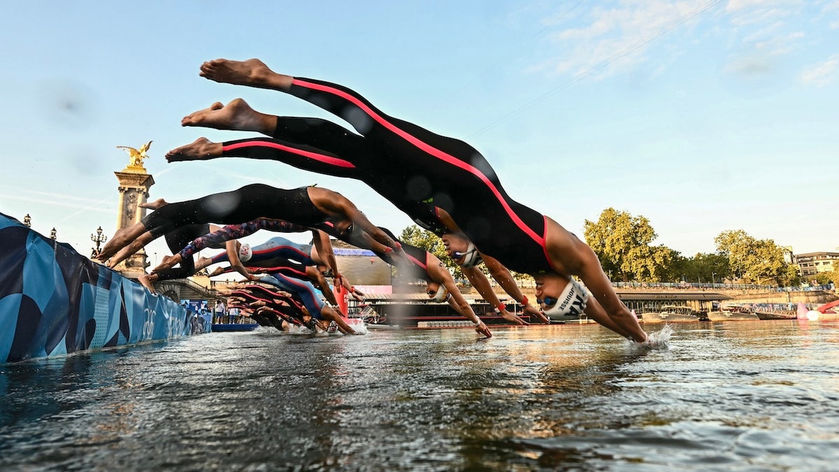 Athletes dive into the Seine River.