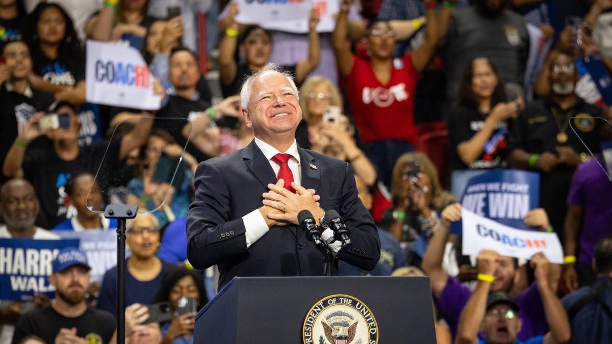 Tim Walz tras el podio en el escenario del mitin de Harris