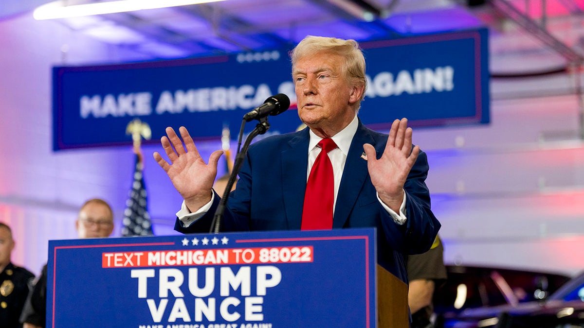 Trump in Michigan with hands up as he responds to a reporter