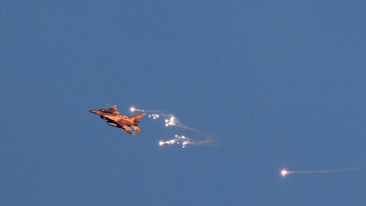 This photo taken from a position in northern Israel shows an Israeli Air Force fighter jet firing flares as it flies to intercept a hostile aircraft that launched from Lebanon over the border area with south Lebanon on August 25, 2024. The Israeli military announced early August 25, 2024 that it was conducting pre-emptive strikes in Lebanon after detecting preparations for "large-scale" attacks by the Iran-backed terror group Hezbollah. Hezbollah claimed it had launched more than 320 rockets at Israel overnight, targeting a string of military positions. (Photo by JALAA MAREY/AFP via Getty Images)