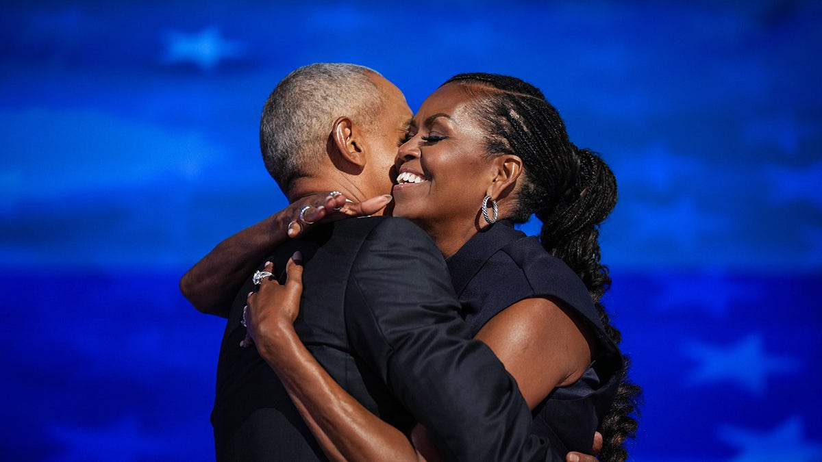 Los Obama se abrazan en el escenario del DNC