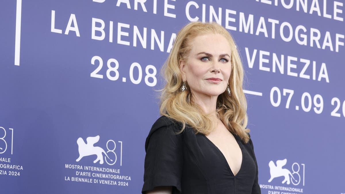 nicole kidman mengenakan gaun hitam di karpet merah di festival film venesia