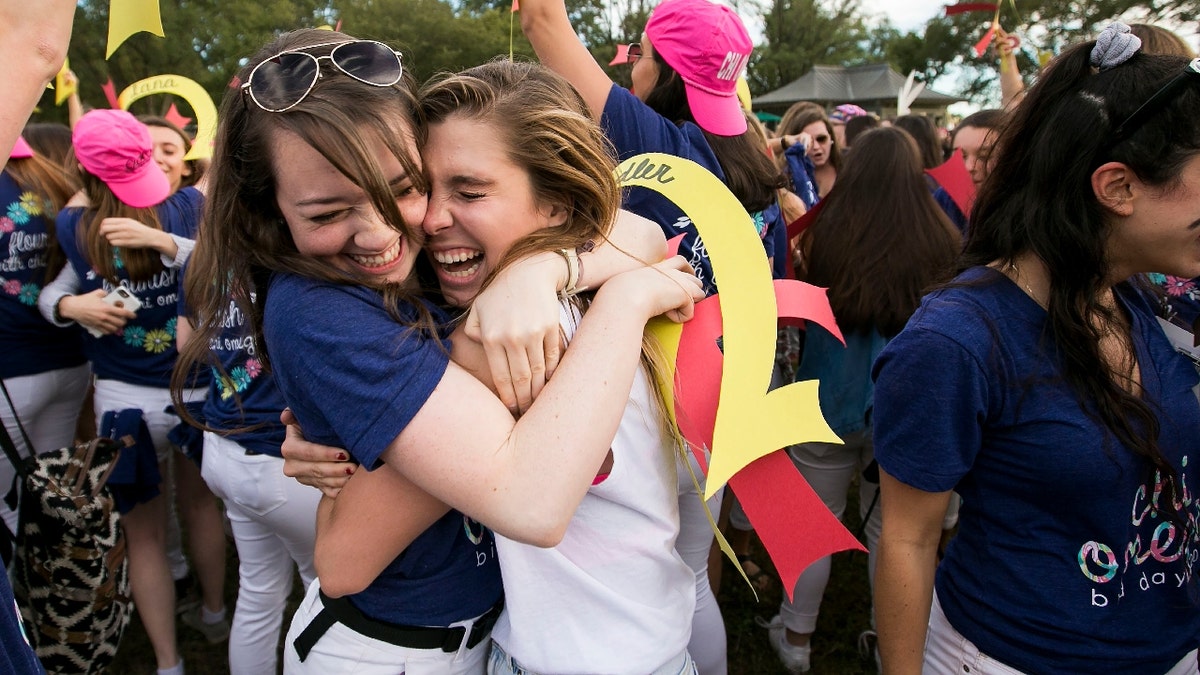 A member of the Chi Omega sorority hugs a new member on Bid Day at George Washington University on the National Mall in Washington, Tuesday, Oct. 6, 2015. 