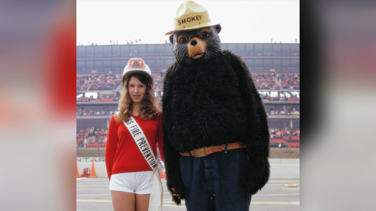 La Joven Miss Prevención de Incendios y el Oso Smokey aparecen en el Indianapolis International Speedway.