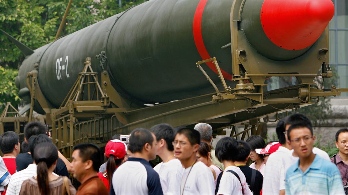 Visitors walk past China's second nuclear missile on display as they visit the Military Museum in Beijing on July 23, 2007.