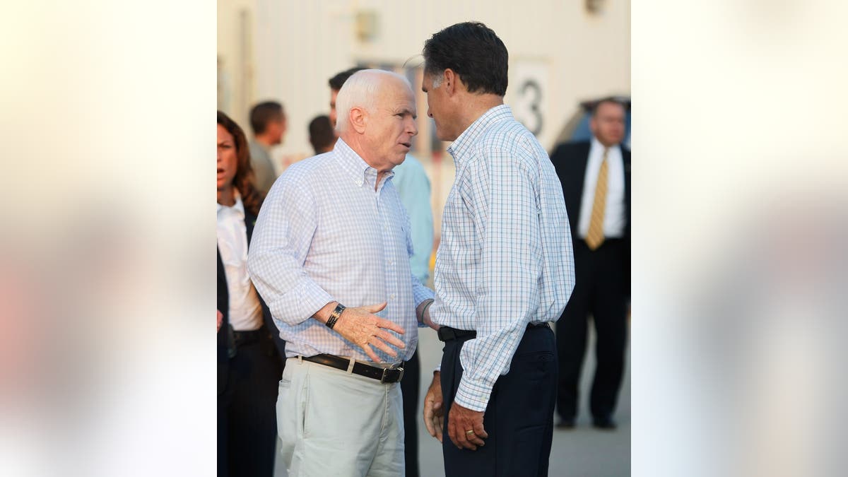 John McCain, left, and Mitt Romney talk at a campaign rally in 2008.