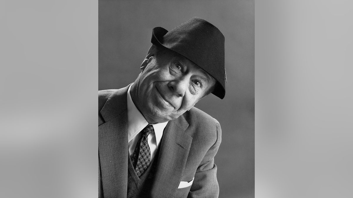 Bert Lahr smiling in a suit wearing a fedora.