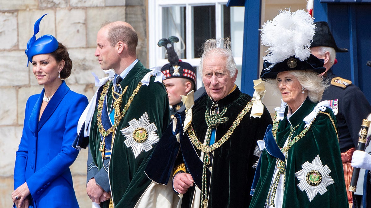 La familia real británica vestida de etiqueta mientras permanecen en fila con semblante serio.