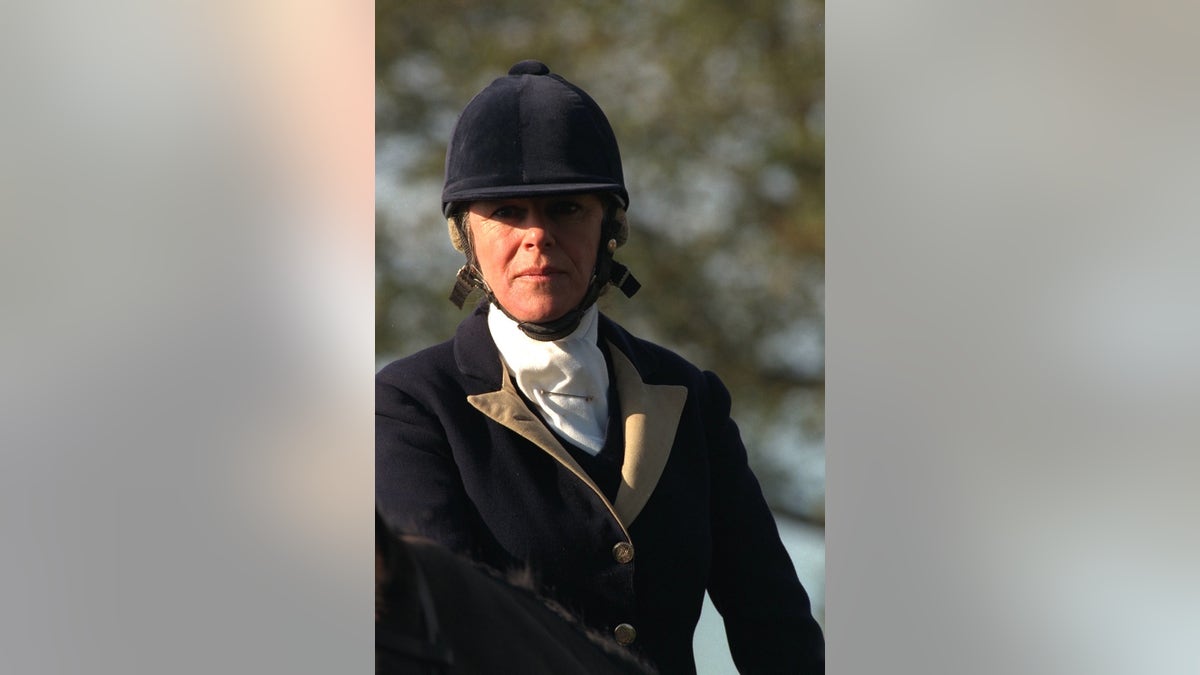 A close-up of Camilla in riding gear looking directly at the camera.