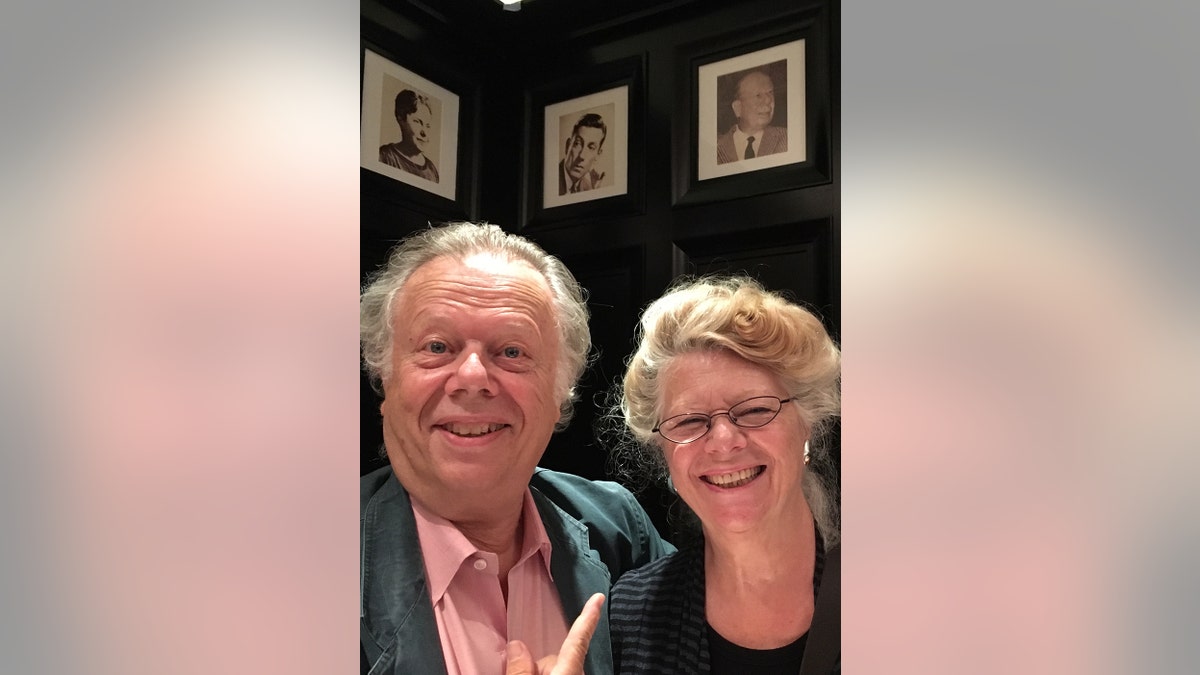 John and Jane Lahr smiling overlooking their fathers portrait.